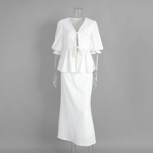Detail of white V-neck ruffle crop top and matching maxi skirt set in textured fabric