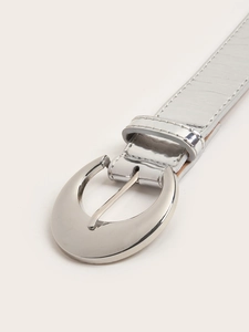 Close-up of a silver embossed leather belt featuring a large polished half-moon metal buckle