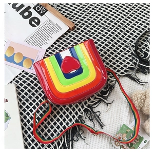 Flat lay of rainbow crossbody bag with heart detail on a black and white grid