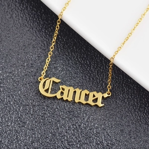 Detailed close-up of gold-plated Cancer zodiac pendant with Old English gothic font lettering