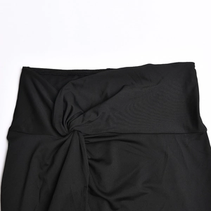 Close-up of the knot design on high-waist black skirt with soft knitted texture