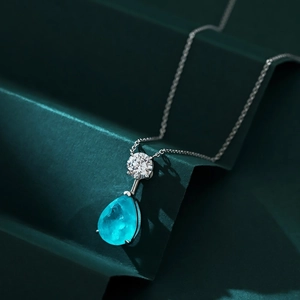 Macro detail of teardrop Paraiba tourmaline pendant necklace in 925 silver setting