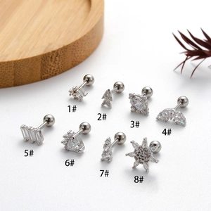 Detailed macro shot of eight assorted silver zircon ear studs in various geometric shapes