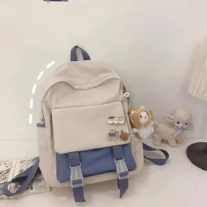 Detail of canvas backpack featuring gray-blue buckles and a cute white puppy plush charm