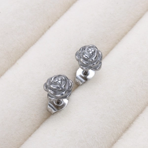 Gros plan de boucles d'oreilles roses argentées avec relief 3D détaillé sur support