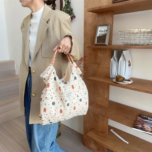 Detail of canvas tote bag with bunny prints and orange braided rope handles