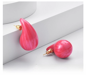Macro shot of chunky pink marbled waterdrop earrings with elegant gold backing studs