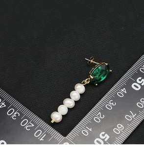 Detailed view of green gemstone earrings with five dangling natural freshwater pearls