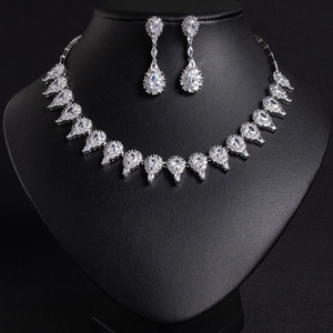 Elegant bridal jewelry set with silver necklace and drop earrings on a black mannequin