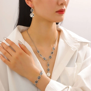 Detailed close-up of irregular black acrylic pendant jewelry set worn by a model
