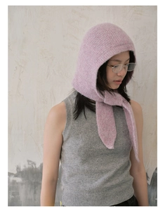 Detail of pink knitted hooded scarf with straps showing soft texture and vintage French style