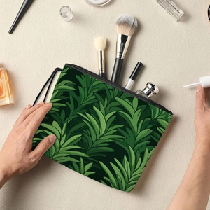 Floral makeup bag with tropical leaf print and zipper closure on a textured surface