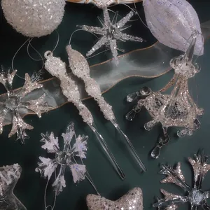 Sparkling silver Christmas ornaments set with snowflake and bell shapes on dark background