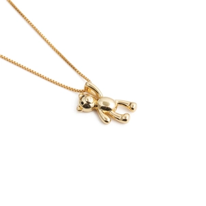 Close-up of a golden teddy bear pendant with a polished finish and fine box chain