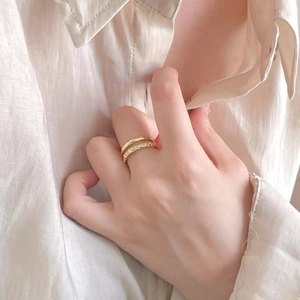 Close-up of minimalist 925 silver double layer rings with hammered gold finish