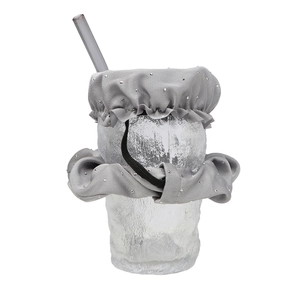 Close-up of grey fabric hair scrunchie drink cover with silver dots on a glass cup
