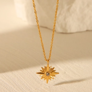 Detailed close-up of a golden stainless steel necklace with an eight-pointed star pendant
