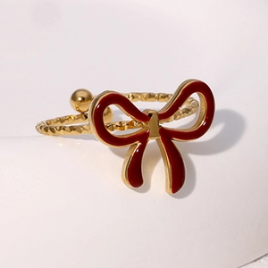 Detailed macro view of a vintage gold bow ring with red enamel and textured band