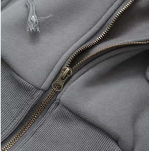 Close-up of bronze metal zipper and knit fabric texture on gray outdoor sports hoodie