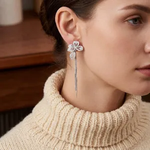 Elegant silver flower earrings with zircon tassels worn by a model in a luxury style
