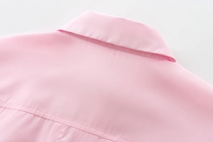 Detailed close-up of pink cotton shirt collar and fine stitching on high-quality fabric