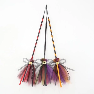 Set of three colorful Halloween witch brooms with mesh ribbons in red, purple, and orange