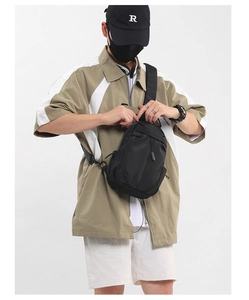 Detail of black oxford fabric sling bag with adjustable strap and multi-layer zippers