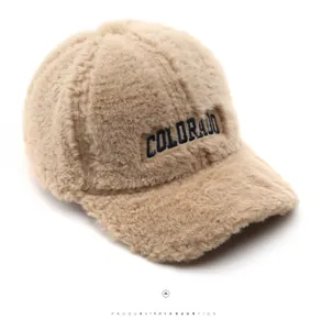Close-up of plush beige baseball cap with navy Colorado embroidery and fuzzy texture
