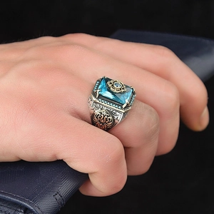 Macro detail of retro ethnic ring with square blue zircon and ornate gold-silver carvings