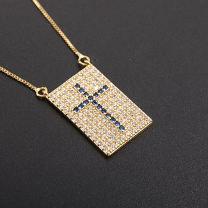 Golden rectangular necklace with white zircon and a blue cross pattern pendant