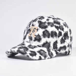 Detail of plush black and white leopard print baseball cap with a gold glittery R patch