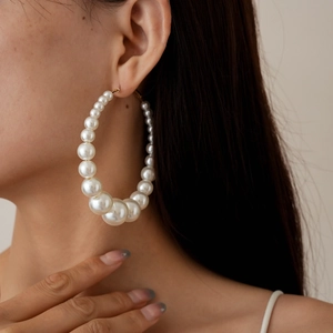 Detailed view of large gradient pearl hoop earring worn by a model in a close-up shot