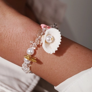 Detail of beach bracelet featuring crushed stone beads, pearls, starfish and seashell charms