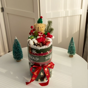 Confezione regalo di Natale con orsetto, figura di Babbo Natale, pigne e bacche rosse