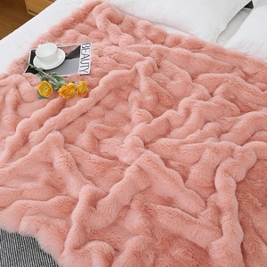 Detailed texture of pink faux rabbit fur blanket on bed with warm home decor accents