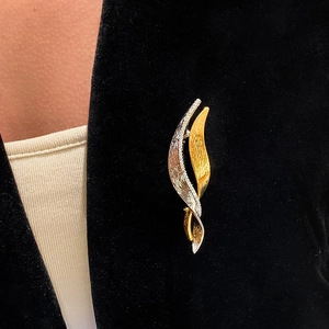 French vintage zircon twisted brooch in gold and silver finish on a black suit lapel