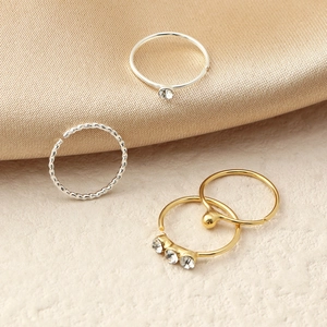 Set of four gold and silver nose rings featuring crystal accents and beaded textures