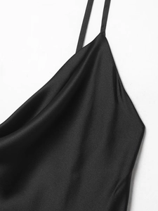 Detailed close-up of a black satin camisole top with thin straps and draped neckline