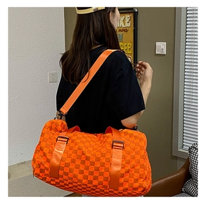 Detailed view of the large orange checkerboard travel bag with adjustable shoulder strap