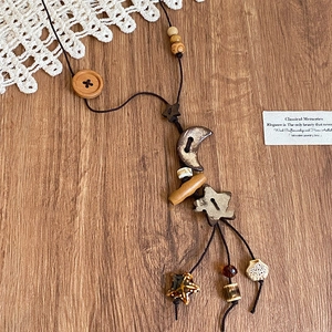 Nahaufnahme einer Boho-Holzkette mit Stern- und Mondperlen auf einem Holzhintergrund