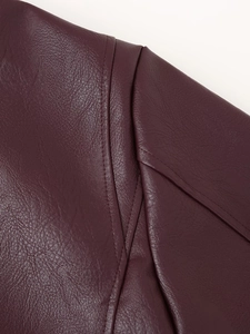Macro view of burgundy PU leather texture with detailed double-stitched seam craftsmanship