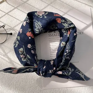 Detailed close-up of dark blue floral cotton scarf with precise edge stitching