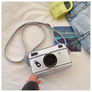 Detailed overhead shot of a silver camera-shaped crossbody bag with metallic PU texture