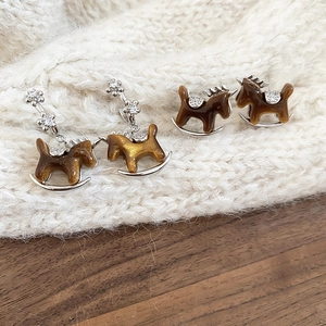 Detailed shot of amber resin rocking horse earrings with sparkling cubic zirconia inlay