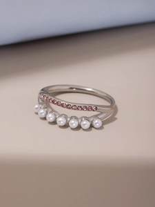 Détail d'une bague double couche argentée avec perles blanches et zircons roses