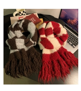 Detail of striped knit scarves with fringe in brown-grey and red-white colorways