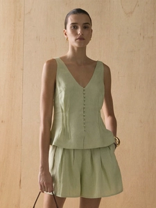 Detail of light green cotton vest set with pleats, buttons and high waist A-line shorts