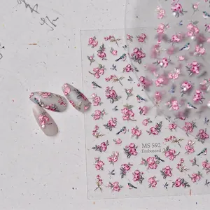 Embossed floral nail stickers with pink flowers and blue birds on textured paper