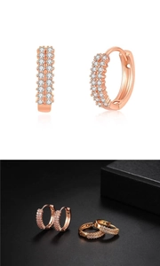 Macro shot of double-row pavé zircon huggie earrings in gold and rose gold finish