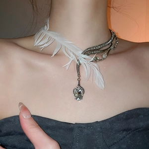 Détail du collier ras de cou plume asymétrique avec cristaux et strass brillants